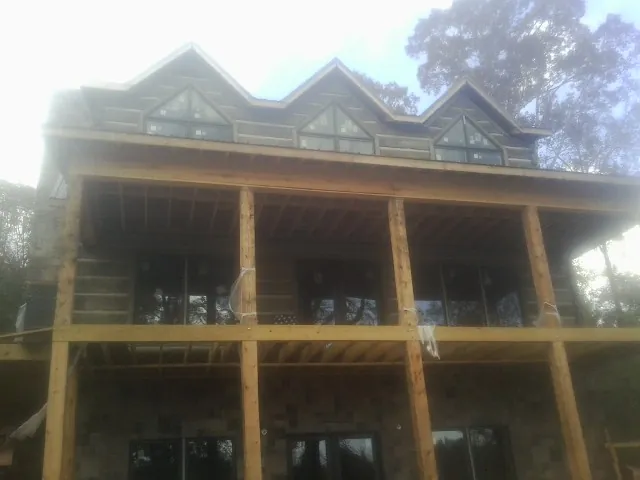 Dormers and porch framing on a large log home under construction — Roof Coating work by our crew in West Nyack