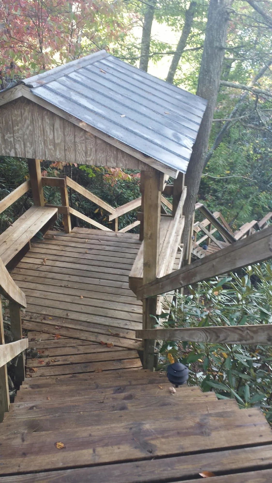 Metal roofed shelter over wooden steps on a wooded walkway — Skylight Repair & Installation work by our crew in West Nyack